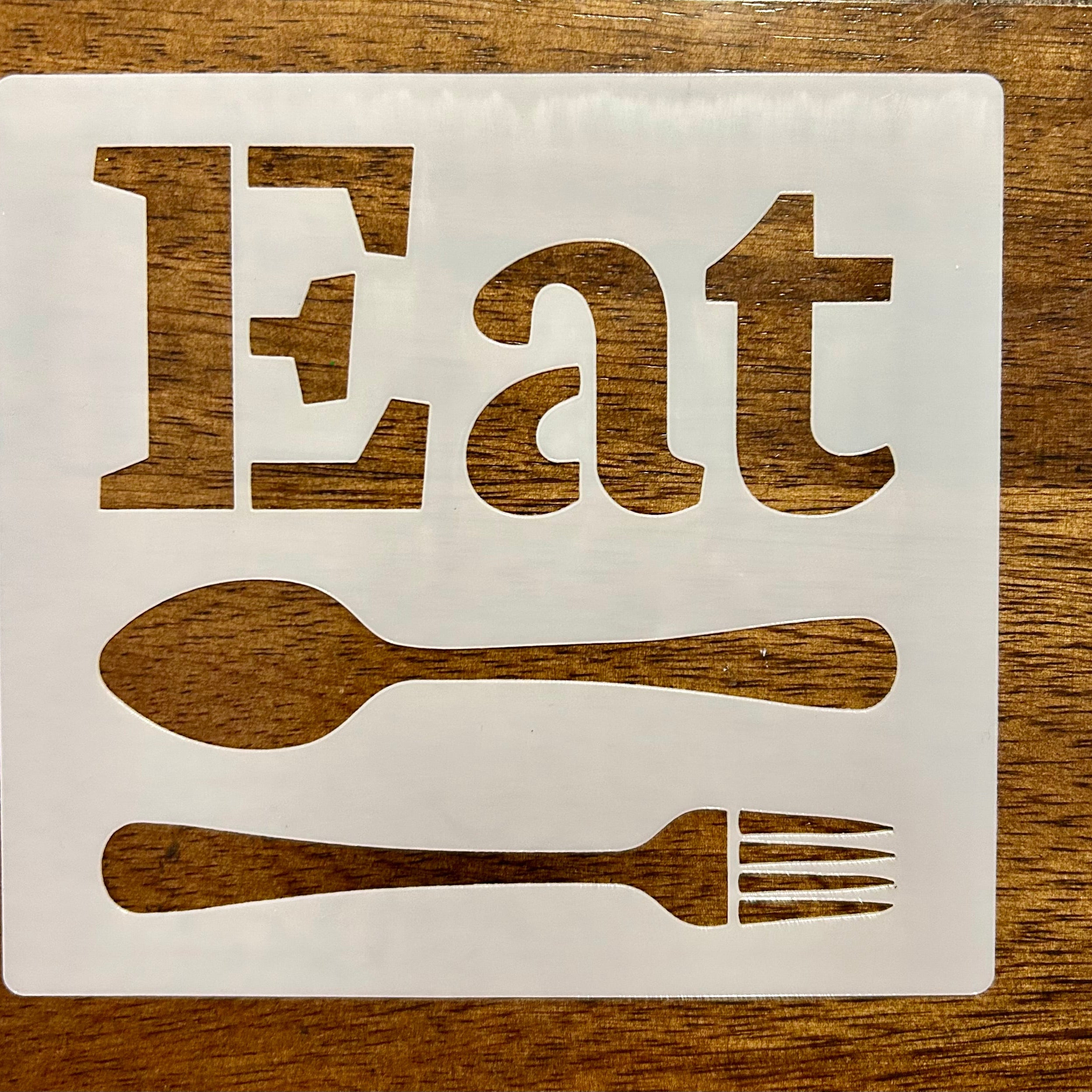 ‘Eat' sign with spoon and fork on a wooden background
