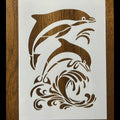 Stylized illustration of dolphins on a white card with a wooden background